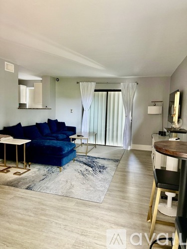 A living room with a blue sofa and a wooden table.