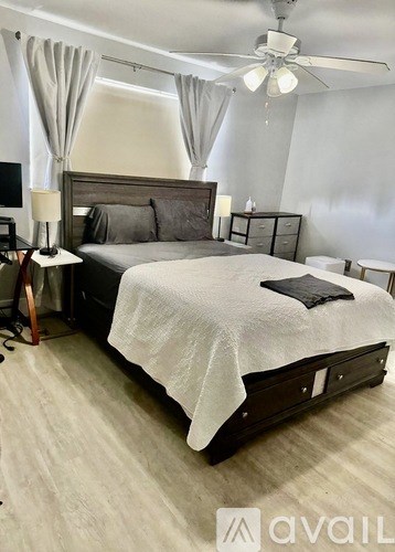 A bedroom with a large bed and a ceiling fan.
