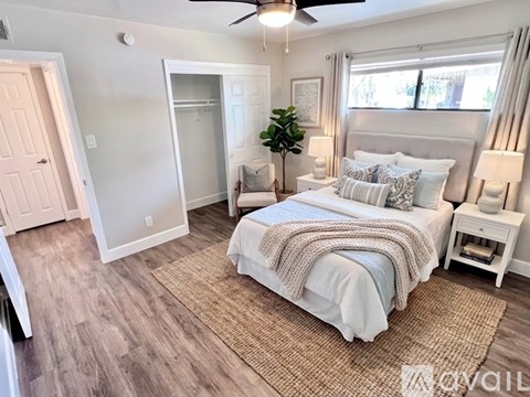 A bedroom with a large bed and a ceiling fan.
