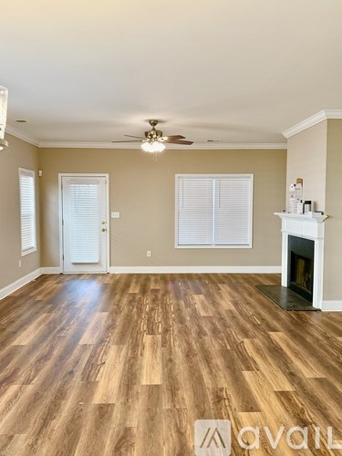 A living room with a fireplace and wood flooring.