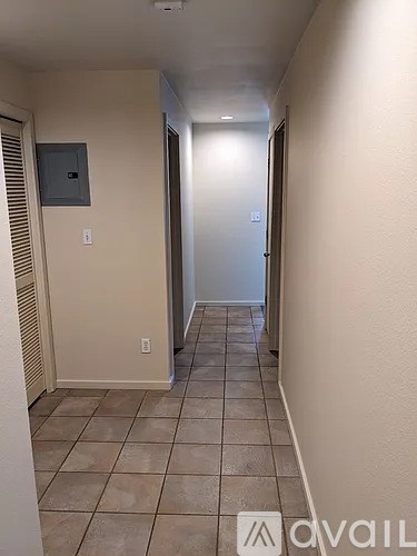 A hallway with tiled floors and a door at the end.