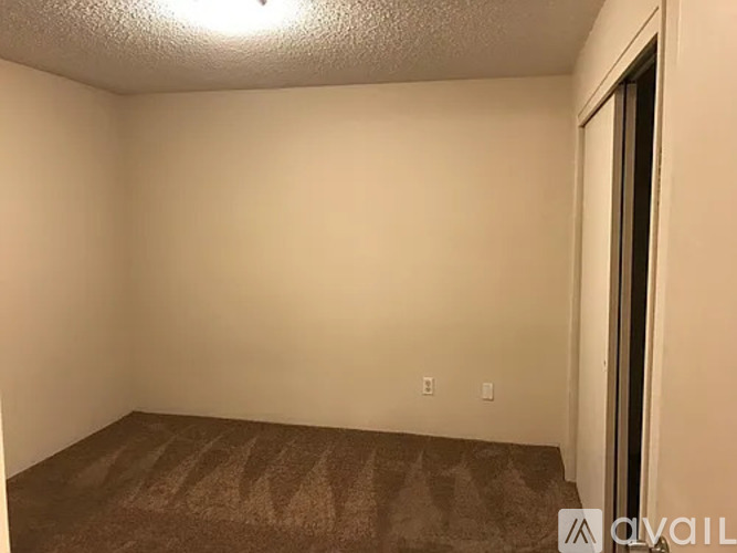 A room with a carpeted floor and a door on the right side.