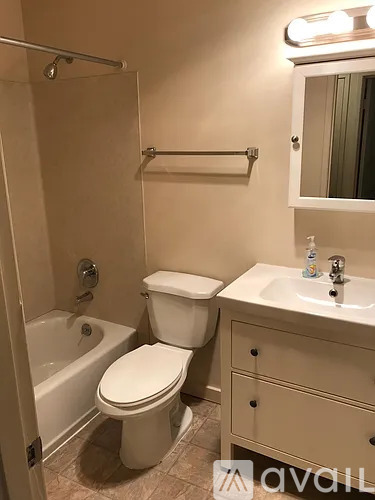 A white toilet sits next to a white sink in a small bathroom.