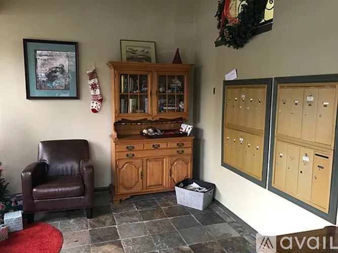 A room with a brown leather chair, a wooden cabinet, and a Christmas tree.