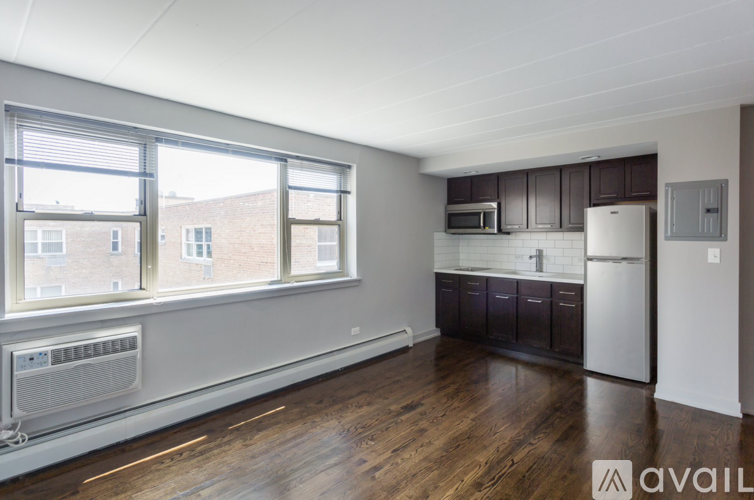 A kitchen with dark wood floors and white appliances.