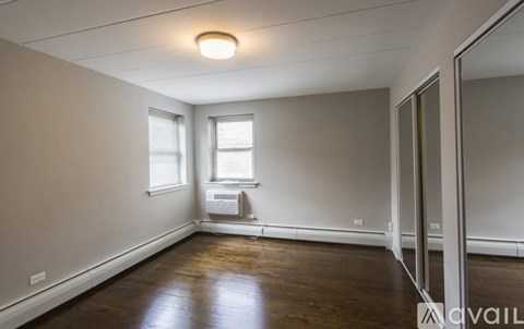 A room with wooden floors and a window with blinds.