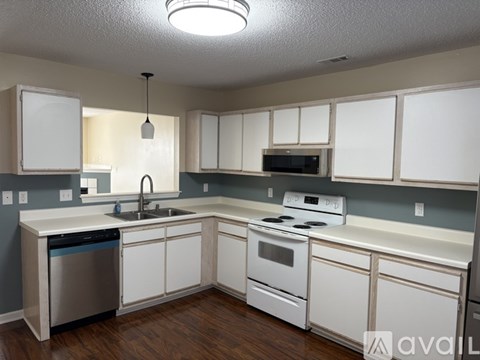 A kitchen with white cabinets and appliances.