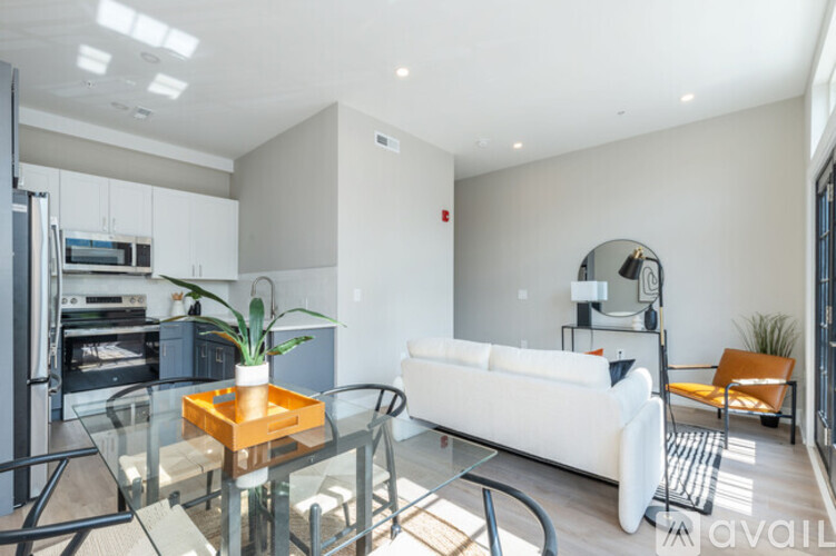 A modern living room with a glass table and white couch.