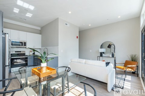 A modern living room with a glass table and white couch.