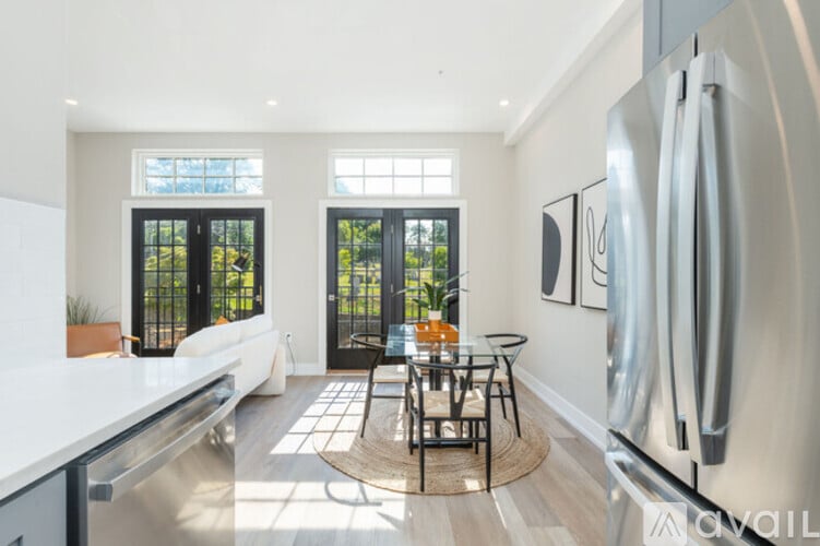 A modern kitchen with a glass door refrigerator and a dining table with chairs.