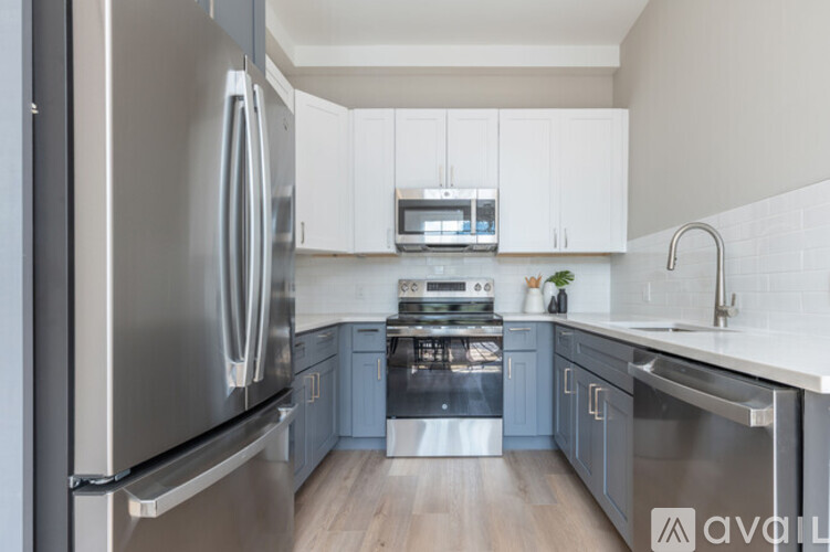 A modern kitchen with a stainless steel refrigerator and oven.