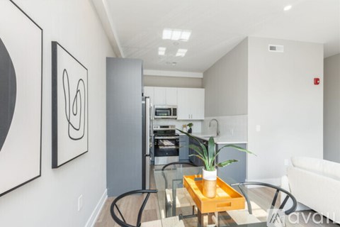 A living room with a couch, coffee table, and a painting on the wall.