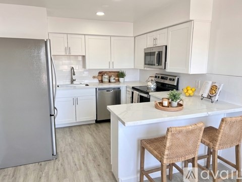 A kitchen with white cabinets and a refrigerator.