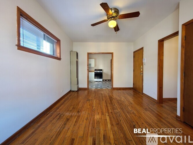 A room with wooden floors and a ceiling fan.