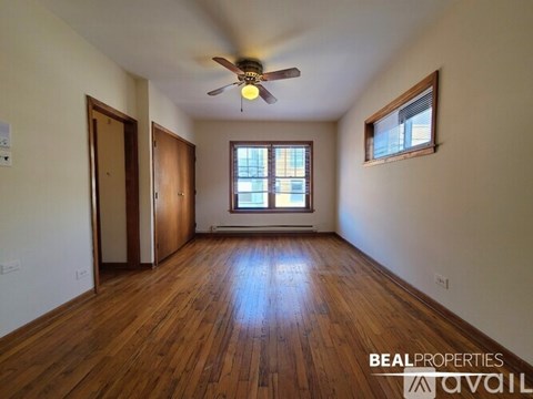 A room with wooden floors and a ceiling fan.