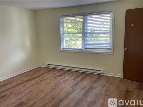 A room with a window and wooden flooring is available for rent.