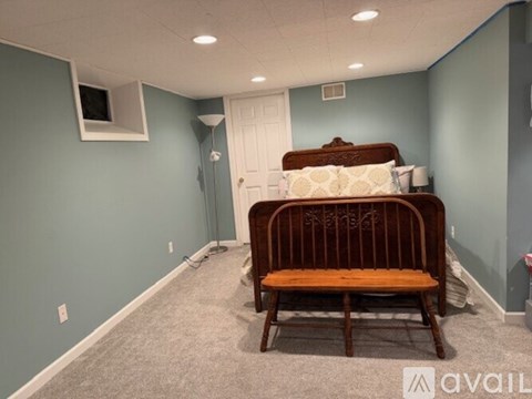 A bedroom with a bed and a chair.