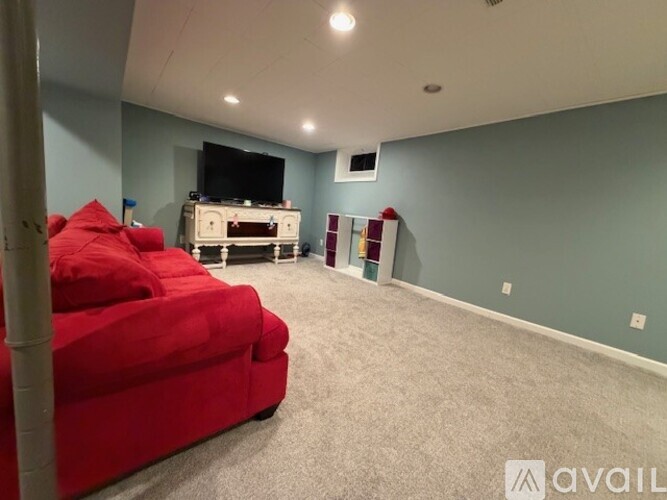 A living room with a red couch and a television.
