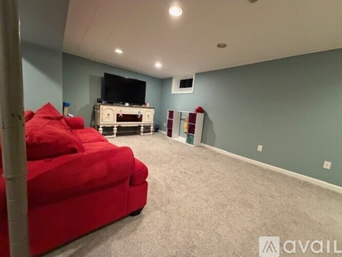 A living room with a red couch and a television.