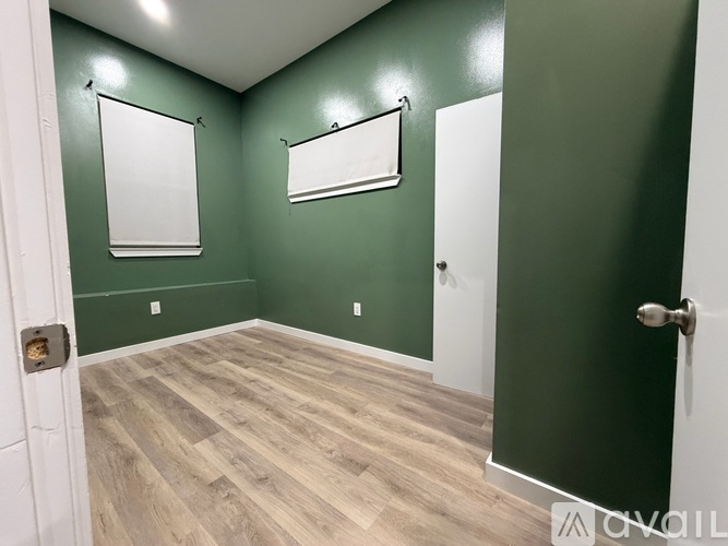 A room with green walls and wood flooring.