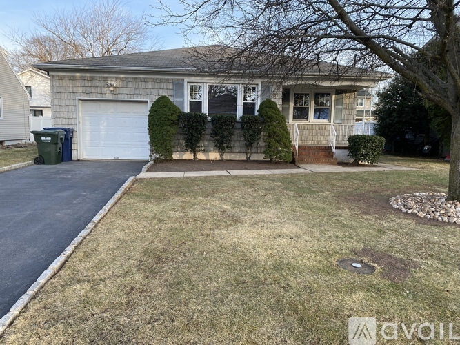 A house with a grey roof and a white garage door.