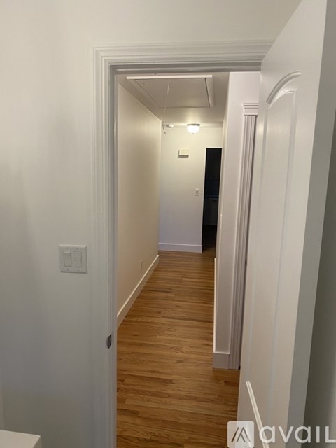 A hallway with a light switch on the wall.