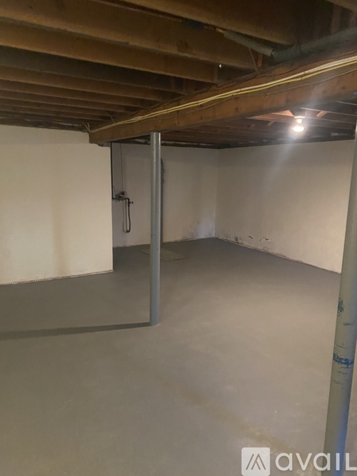 A room with a white wall and a grey floor.