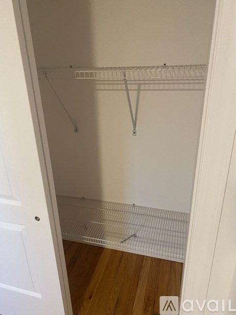 A room with a white wall and a grey floor.