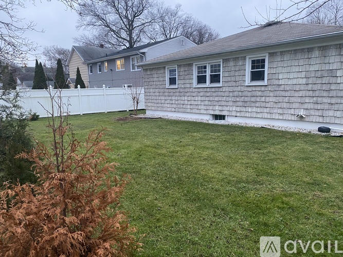 A house with a grey roof and a white fence.