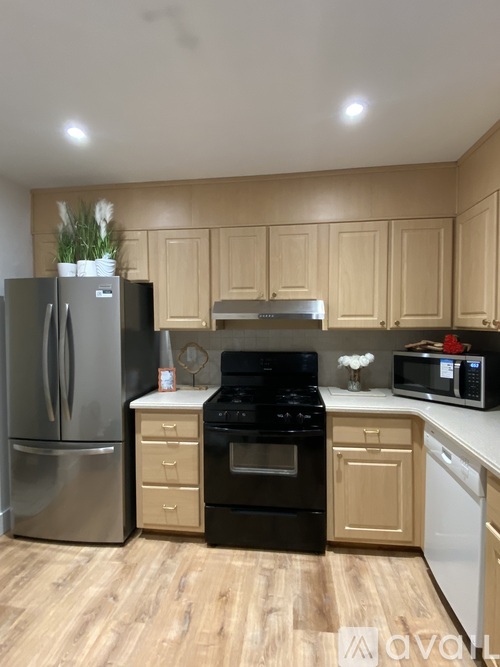 A kitchen with wooden cabinets and a stainless steel refrigerator.