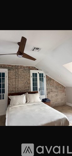 A bedroom with a bed and a ceiling fan.