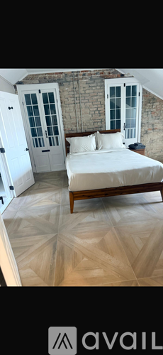 A bedroom with a bed, a door, and a window.