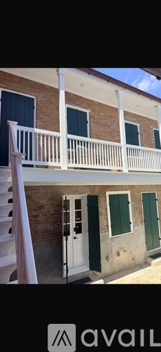 A building with a white balcony and green doors.