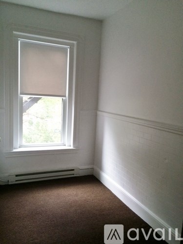 A room with a window and a carpet.