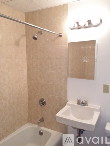 A bathroom with a tub, sink and shower.