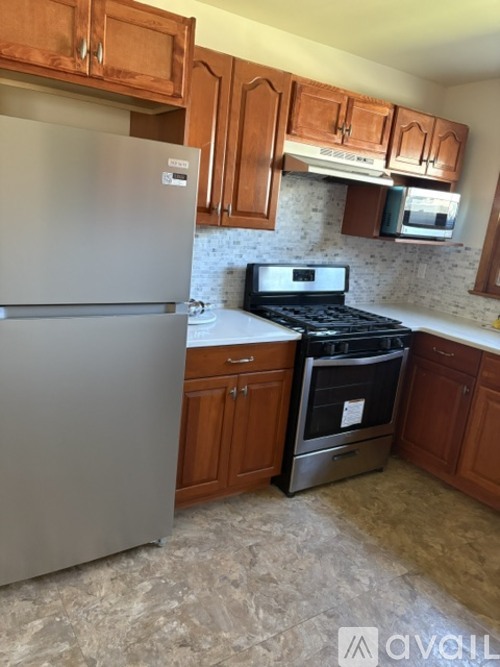 A kitchen with a stainless steel refrigerator and a stove top oven.