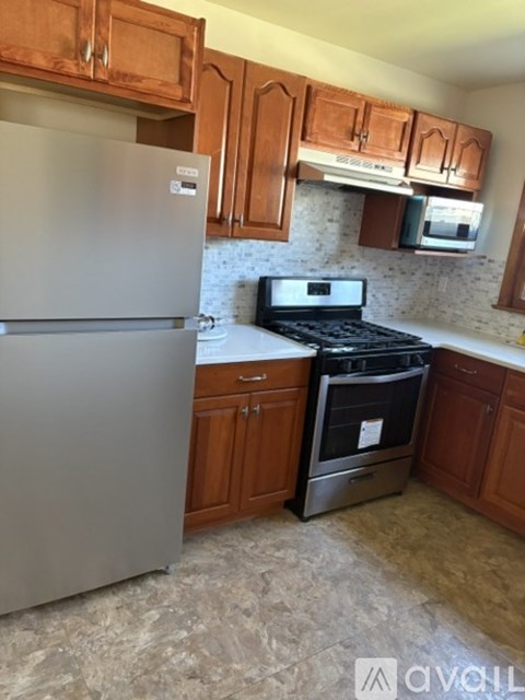 A kitchen with a stainless steel refrigerator and a stove top oven.