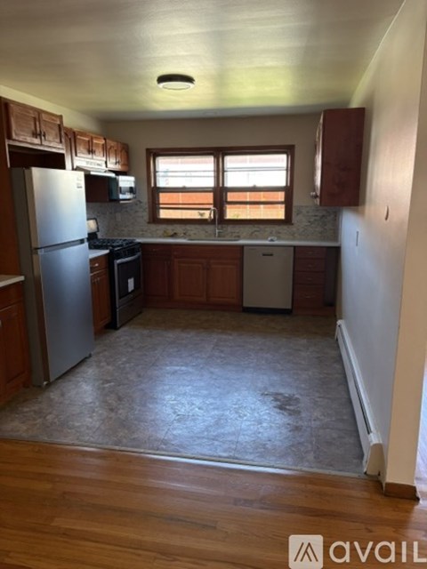 A kitchen with wooden cabinets and a refrigerator.
