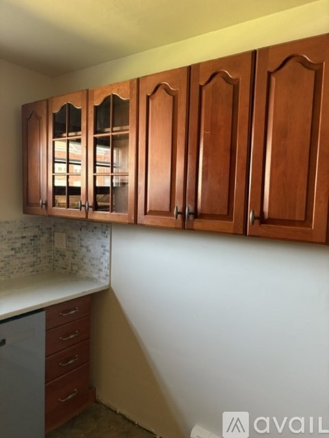 A kitchen with wooden cabinets and a white countertop.