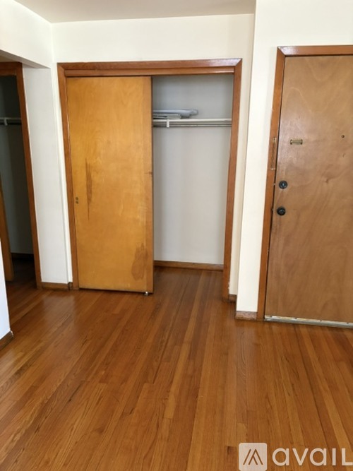 A room with a wooden floor and two doors.