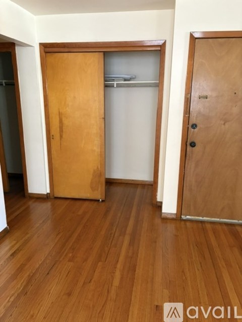 A room with a wooden floor and two doors.