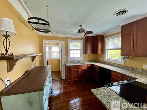 A kitchen with wooden cabinets and a black stove top.