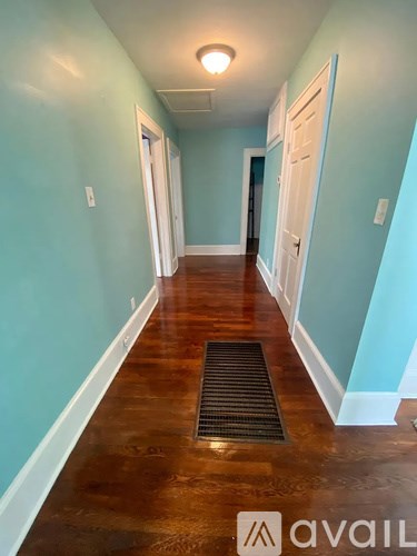 A long hallway with a mat on the floor and doors on both sides.