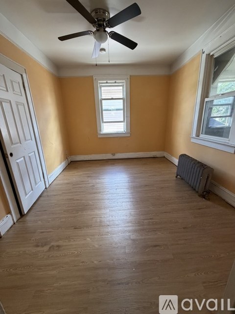 A room with wooden flooring and a ceiling fan.