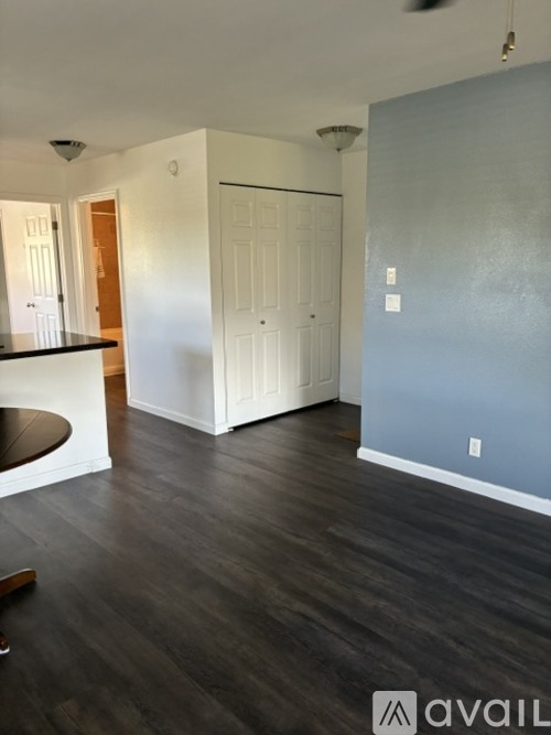 A room with a white door and a wooden floor.