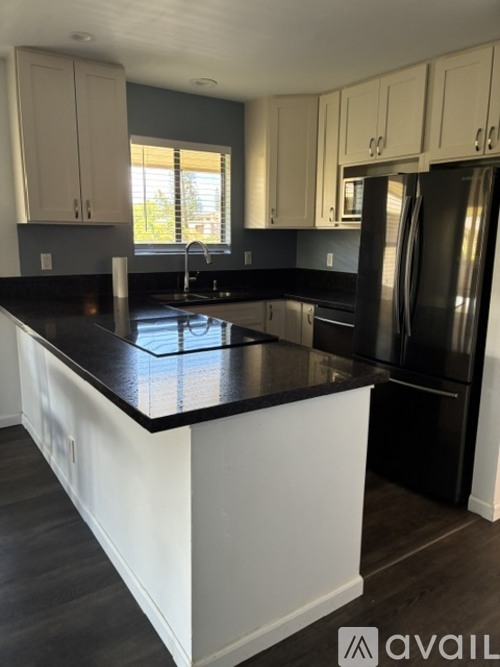 A kitchen with black countertops and white cabinets.