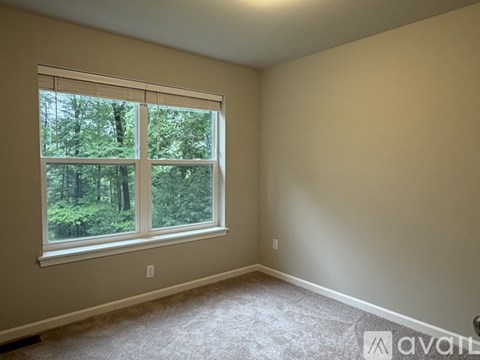 A room with a large window overlooking a forest.