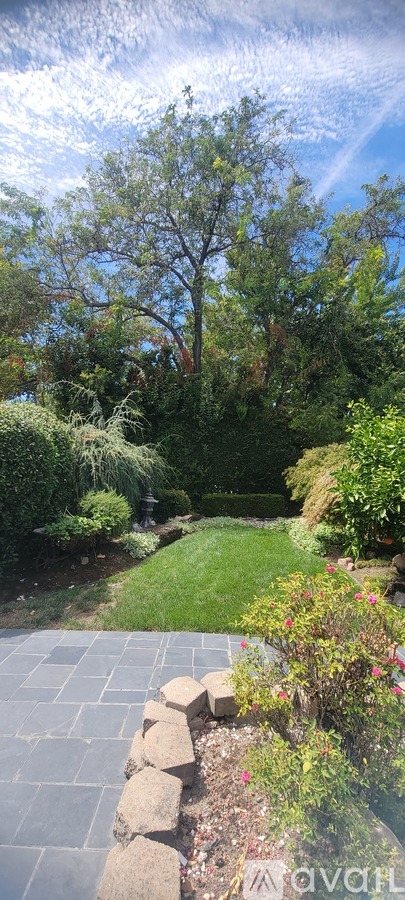 A stone pathway leads through a lush garden.