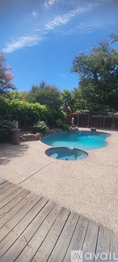 A small pool in a backyard with a wooden deck.