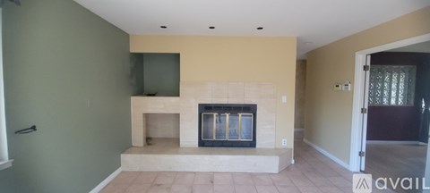A living room with a fireplace and a green wall.
